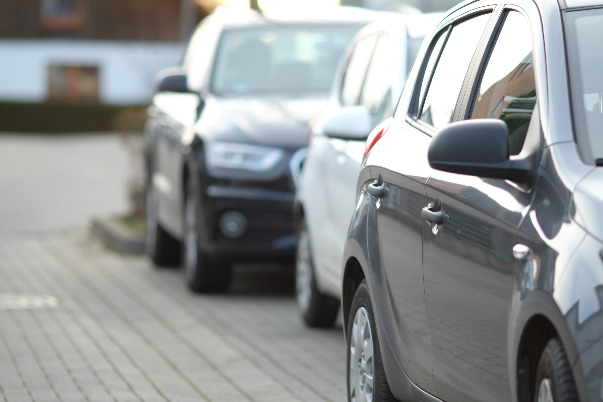 close up view of cars parked in line behind each other in a car park